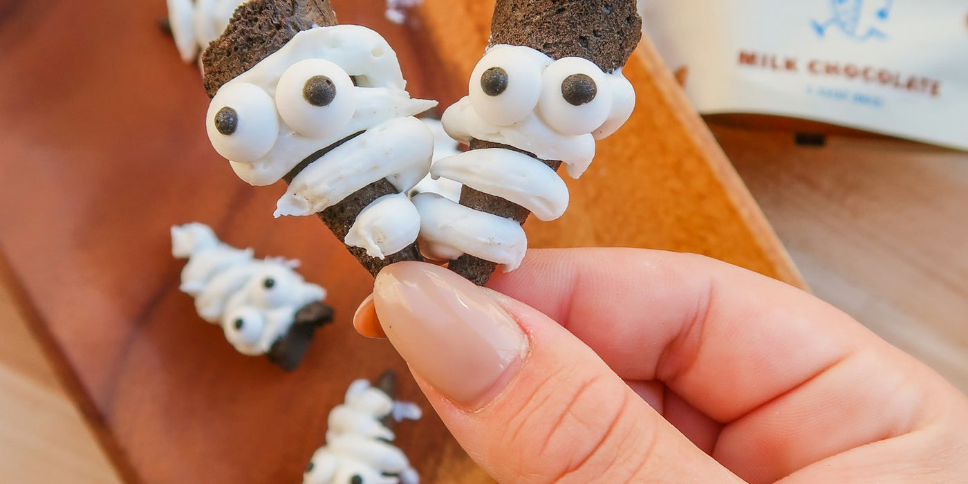 Image of Muddy Bites decorated to look like mummies, labeled as 'Mummy Bites' with a festive Halloween theme.